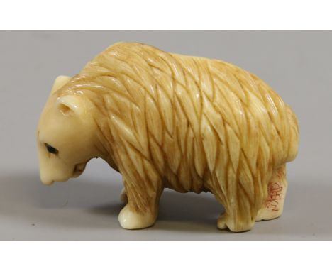 A Japanese netsuke formed as a bear, signed. Condition Report. To be used as a guide only. Good condition.