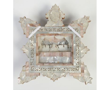 An olive wood and mother of pearl diorama depicting the last supper within a deep, shaped frame ornamented with fretwork, 22c