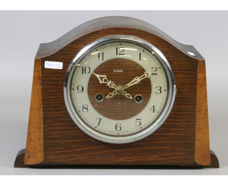 An Enfield oak cased mantel clock. The Arabic numeral dial encloses twin train movement.