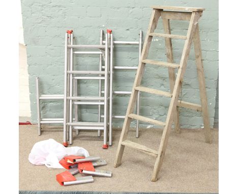 A pair of old wooden steps along with a six section aluminium ladder and accessories.