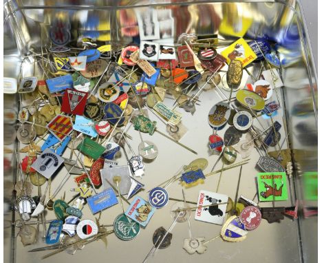 A tin of assorted pin badges including enamel examples.