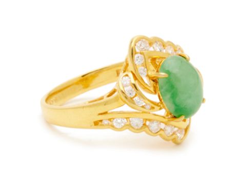 A JADE AND DIAMOND RING A 20k yellow gold band with central cabochon jade with intersecting diamond studded shoulders of vary