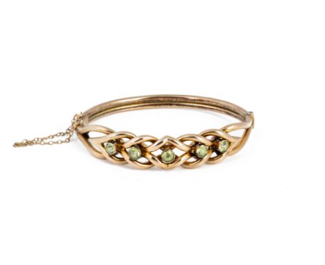 A HOLLOW GOLD BANGLE WITH BRAIDED DESIGN A 9k hollow gold braided design bangle with five pale yellowish green gemstones.
Mar