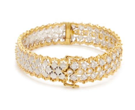 A DIAMOND SET BANGLE
A yellow metal bangle set with 52 brilliant round cut diamonds to one side, set within scalloped borders