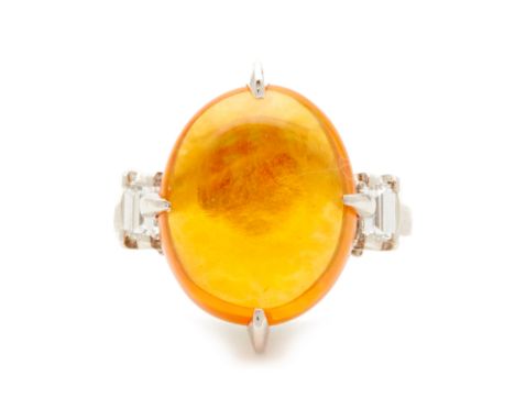 A PLATINUM AND FIRE OPAL RING A large fire opal stone set in a platinum band flanked by two step cut diamonds to either side 