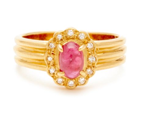 A YELLOW GOLD, RUBY AND DIAMOND RING
An 18k yellow gold band shaped into three strands with central oval cabochon ruby with t