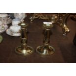 A pair of antique brass candlesticks