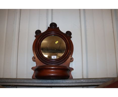 An Edwardian mahogany hanging shelf with circular mirror and bow fronted recess, approx. 57cm high