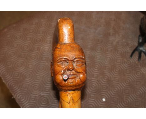 A carved walking stick, the head in the form of Winston Churchill smoking a cigar 
