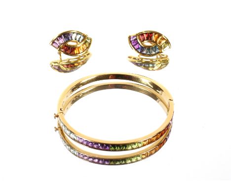 A yellow metal snap bangle marked 750, set with multicoloured stones, 7.5gms total weight; and a pair of matching ear-rings, 