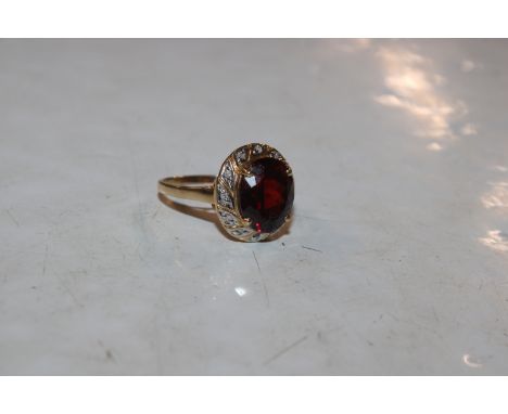 A 14ct gold ring set with chip diamonds and large central red coloured stone, approx. total weight 4.4gms, ring size R