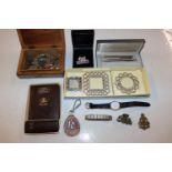 A box containing various coinage, bracelets, wrist
