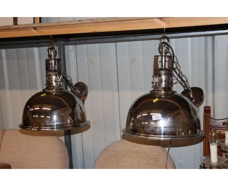 A pair of modern chrome industrial style light fittings