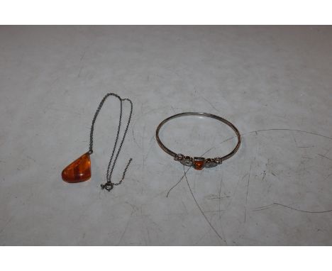 A 925 silver and amber set bangle and a 925 marked necklace hung with amber coloured pendant 
