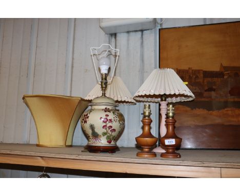 A pair of pink painted turned wooden table lamps and shades; one other pair of wooden table lamps and a pottery crackle glaze