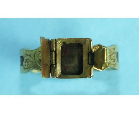 A Victorian yellow metal mourning ring, the hinged front opening to reveal a locket within, (vacant, no glass), the shank ins