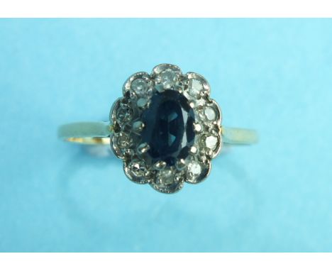 A sapphire and diamond cluster ring claw set an oval sapphire within a surround of ten 8/8 cut diamonds, size P, 2.7g.