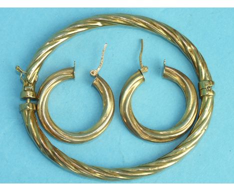 A 9ct gold hinged bangle of twist design and a pair of matching earrings, 8.9g.
