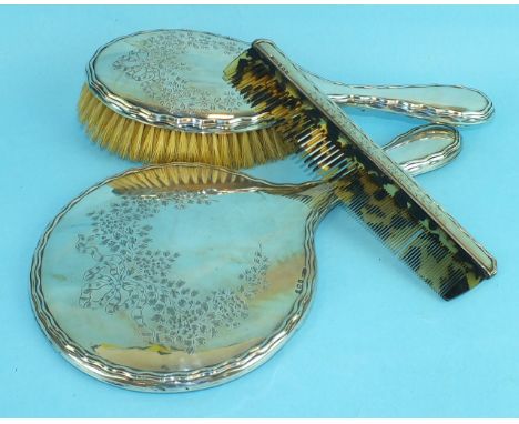 A silver-backed hand mirror, hair brush and comb, Birmingham 1920, (3).