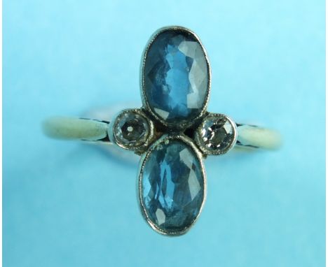 An Edwardian aquamarine and diamond ring collet-set two oval aquamarines between two brilliant-cut diamonds, in 18ct yellow g