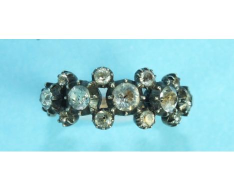 A Georgian gold and silver ring set thirteen white paste stones in three lines, in cut-down settings, on gold reeded shank, w