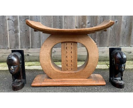 A vintage African wooden tribal birthing stool, 43cm high, 51cm long, 24cm wide, along with carved tribal heads 