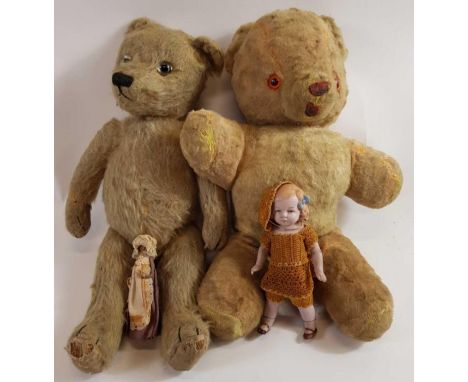 A vintage straw filled jointed teddy bear, set with glass eyes, along with another teddy bear and two dolls