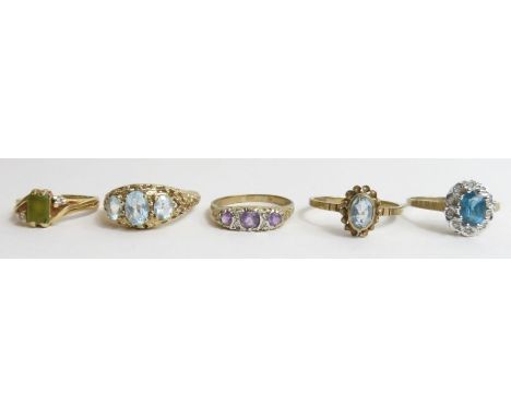 A 9ct gold blue topaz single stone ring, a 9ct gold amethyst and diamond carved head ring, together with two other 9ct gold g