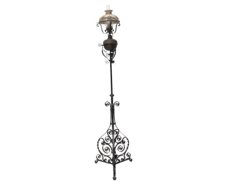 A late 19th/early 20thC wrought iron adjustable floor lamp, with reservoir for oil, and later electric fitting, 204cm high ov