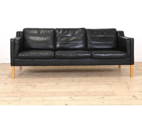 A Danish black leather three-seater settee, raised on light birch supports, 201cm wide 84cm deep76cm high, seat 43cm highBuyi