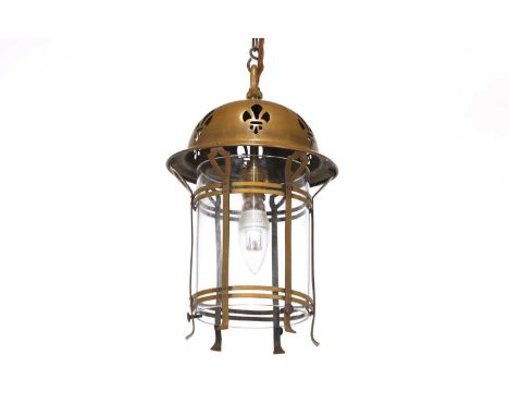An Arts and Crafts brass hanging lantern, with a fret cut domed top, with a clear glass sleeve and strapwork mounts, 20cm dia