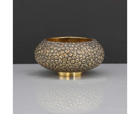 A silver-gilt bowl,by Stuart Devlin, London 1969,of squat from with a 'pebbled' body, on a low foot, 10cm diameter5cm high, 7