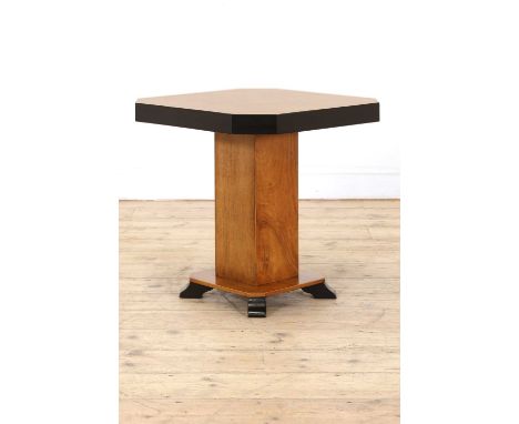 An Art Deco walnut and ebonised lamp table, the quarter-veneered top with canted corners and an ebonised edge, raised on a pl