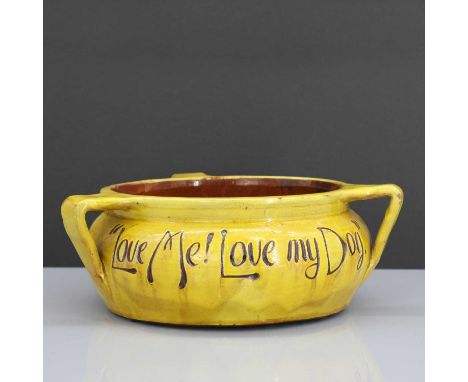 A rare Liberty &amp; Co. yellow pottery dog bowl,by C H Brannam, inscribed 'Love Me! Love My Dog', with three lug handles, im