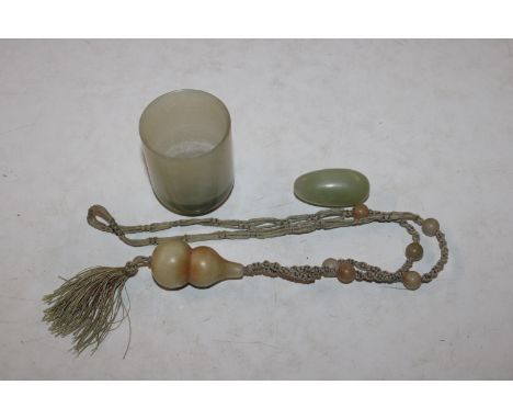 A jade coloured cup; a necklace and a bead