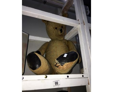 A straw filled old teddy bear with glass eyes