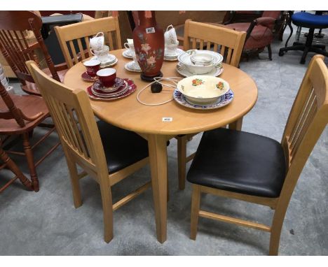 A light wood exteding dining table and 4 leather seated chairs