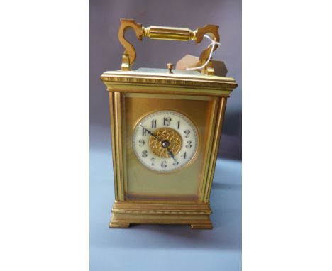 A French gilt brass repeating carriage clock, the gilt dial with enamel chapter ring with Arabic numerals, the twin barrel mo