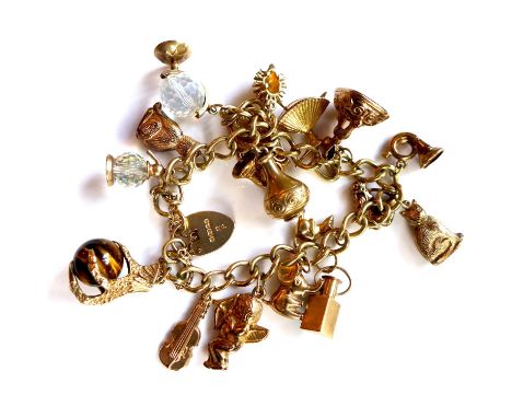 A 9ct yellow gold vintage Ladies Charm bracelet, having 18 charms attached. Approx 41.8g 