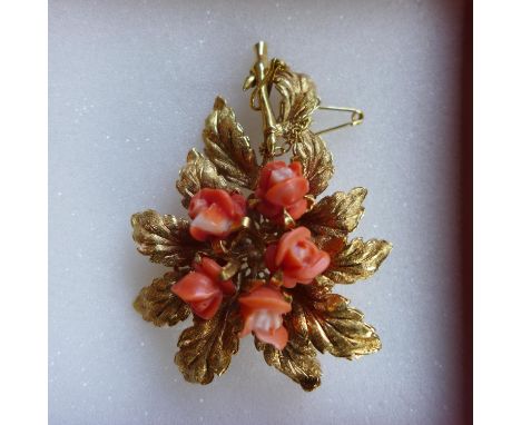 An 18ct yellow gold vintage brooch in the form of a leaf with central coral rose flower heads, safety chain attached (boxed) 