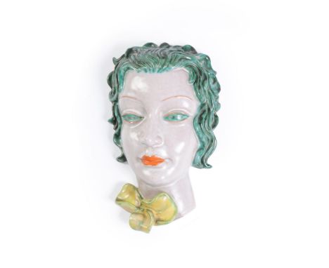 Goldscheider, a painted terracotta wall mask of a lady with a bow, mid to late 1930s, printed mark, model 6911, 26cm high