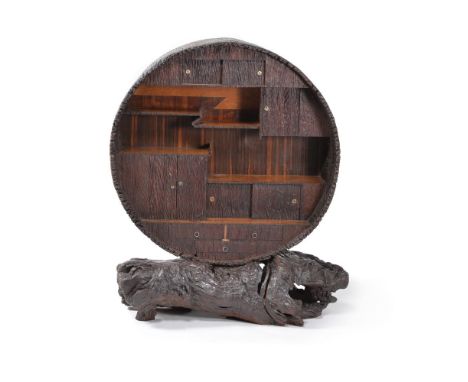 A Japanese wooden open display cabinet, early 20th century, the base simulating a tree trunk, the circular cabinet finished t