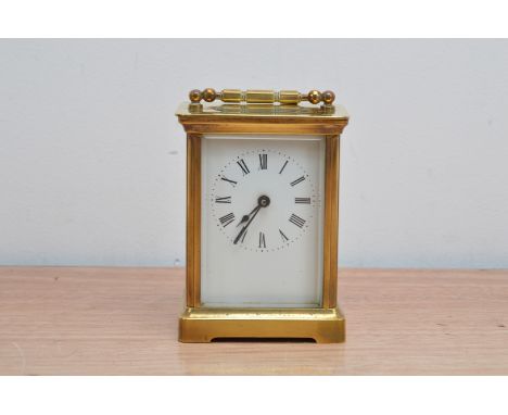 A turn of the century brass French carriage clock, by A.C.C., and marked to the reverse, white enamel dial with roman numeral
