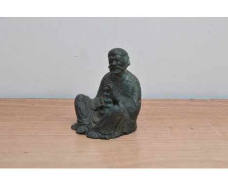 A 20th century bronzed figure of a Chinese man, holding a lamp, with some wear, 11.5cm high 