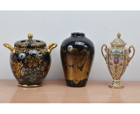 A 20th century porcelain twin handled vase, heightened gilt on a black ground with cover 24cm high, together with a black por