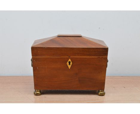 A 19th century mahogany tea caddy, with a two compartment interior, two metal carrying handles, raised on bun brass feet, 15c