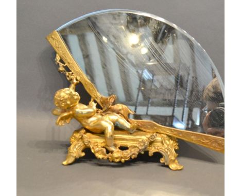 A Gilt Bronze Table Mirror in the form of Putti with a Fan upon shaped scroll feet, 25 cms tall 