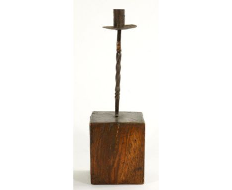AN IRON CANDLESTICK ON ROUGH HEWN WOOD BASE, 41CM H