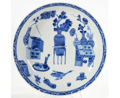 A CHINESE BLUE AND WHITE SAUCER DISH, PAINTED WITH OBJECTS AND A TWO LEGGED CREATURE, THE UNDERSIDE WITH THREE SPRAYS, 25.5CM