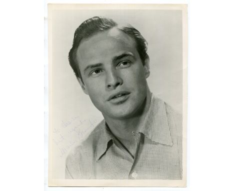 AUTOGRAPH. A black and white photograph of Marlon Brando signed in blue ink, 195mm x 256mm.Buyer’s Premium 29.4% (including V